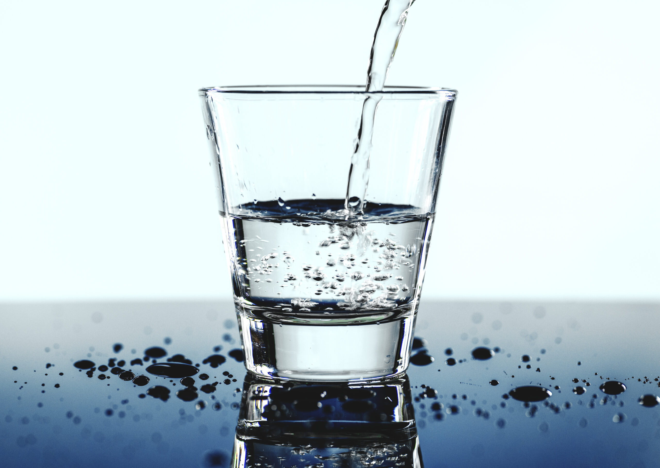 a glass of water with blue background