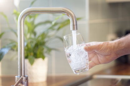 filling up a glass with water from kitchen faucet