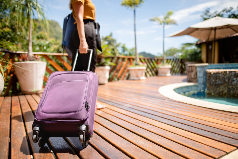 woman with suitcase at a tropical resort for her vacation
