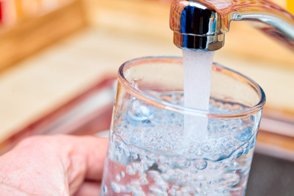 filling up a glass with water from kitchen tap