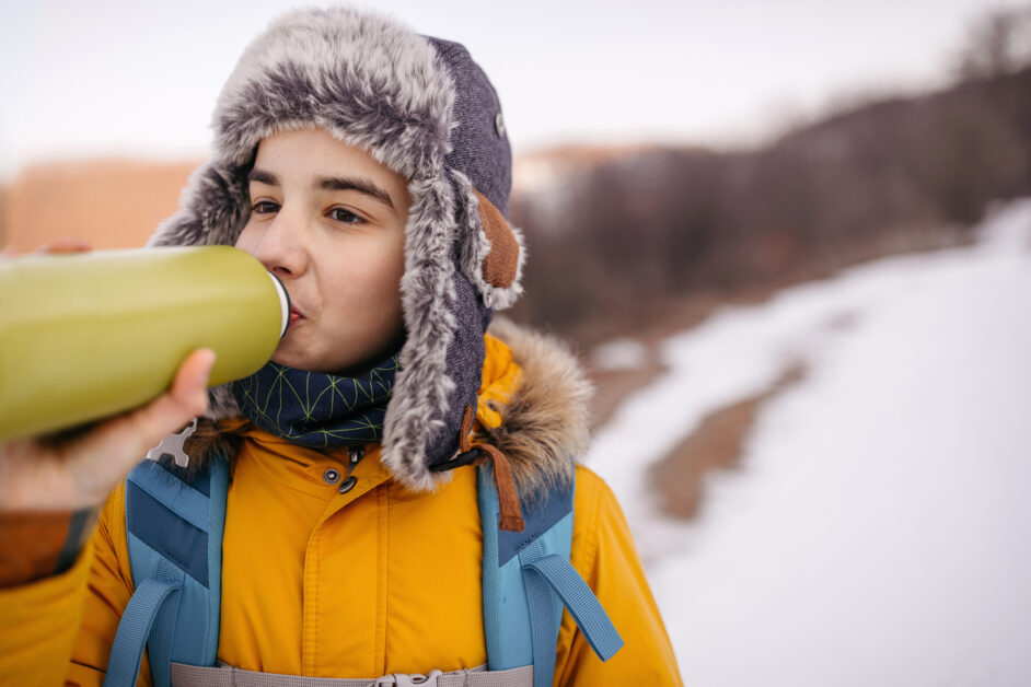 boy drinking water while hiking