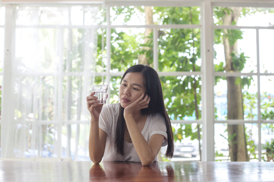 woman looking at glass of water