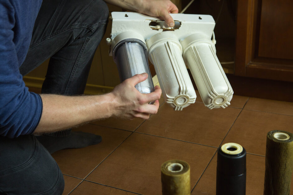 man installs flasks with new filters in the system